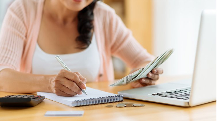 lady with a notepad and computer managing bills