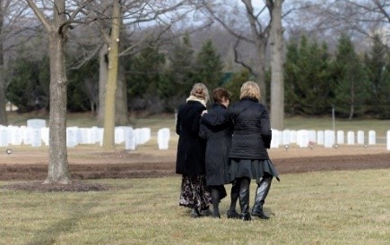 3 people walking in a veteran cemtery