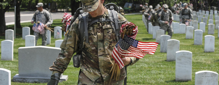 Soldier placing flags at Arlington Cemetery