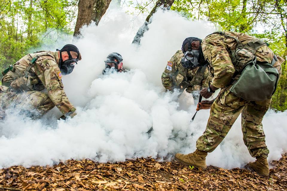 soldiers wearing masks  standing in the middle of a cloud of smoke