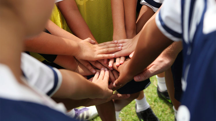 athletes hands staked together in a circle