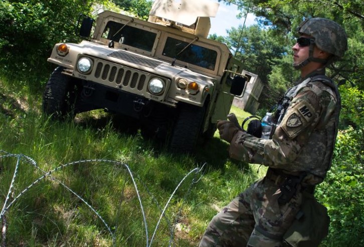 Soldier walking next to a humvee