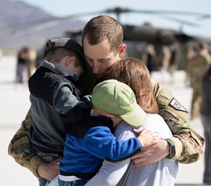 soldier hugging his family