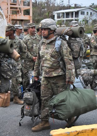 Soldiers holding their gear