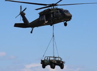 Helicopter lowering a humvee