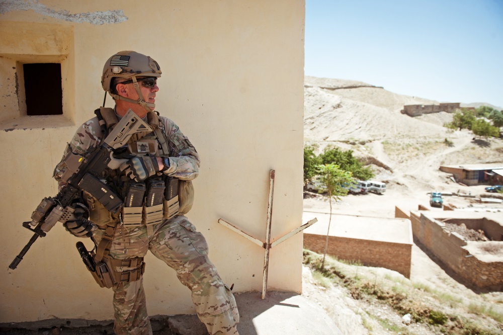 Soldier standing against a building in full combat gear