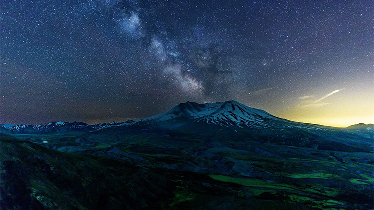 starry sky over a snowcapped mountain